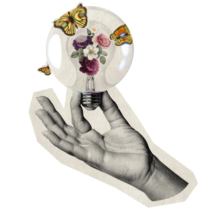 Main tenant une ampoule avec des fleurs et des papillons